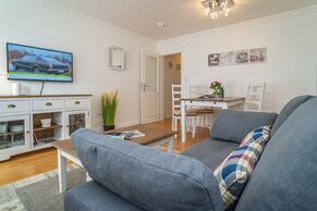 Wohnzimmer mit Schlafcouch, TV und Essplatz