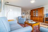 Wohnzimmer mit Sofa, Sessel und Schrankbetten