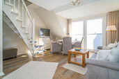 Wohnzimmer mit Sofa, Essplatz, TV und Treppe