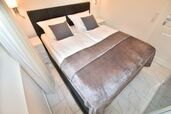 Schlafzimmer mit hochwertigem Boxspringbett und Schwebetürenkleiderschrank