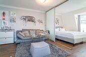 Wohn-/Schlafraum mit Sofa und feststehendem Doppelbett