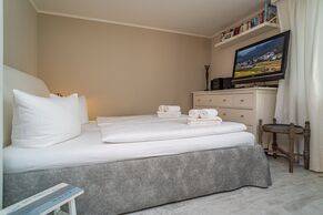 1-Zimmer-Appartement mit feststehendem Doppelbett und TV