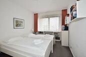 Schlafzimmer mit Doppelbett und Fenster