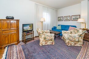 Wohnzimmer mit Sofa, Sessel und TV