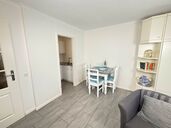 Wohnzimmer mit Esstisch und Zugang zur Küche