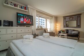 kombinierter Wohn-/Schlafbereich mit Doppelbett, TV und gemütlicher Couch