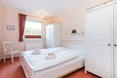 Schlafzimmer mit feststehendem Doppelbett und Fenster