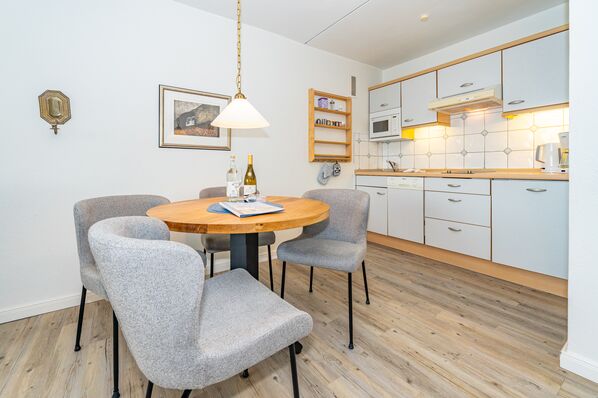 Wohnzimmer mit Sitzmöglichkeiten, TV und offener Küchenzeile