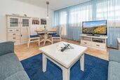 Wohnzimmer mit Sofa, TV und Essplatz