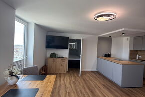 Wohnzimmer mit TV, Essplatz und offener Küche