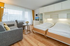 kombinierter Wohn-/Schlafbereich mit Essplatz, Sofa und Sessel 