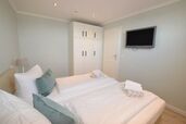 Schlafzimmer mit Boxspringbett und TV