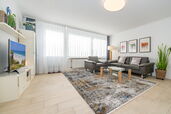 Wohnzimmer mit Sofa, Sessel und TV