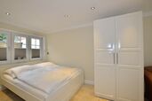 Wohn-/Schlafbereich mit feststehendem Doppelbett und Kleiderschrank