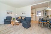 Wohnzimmer mit offener Küche, Essplatz und Sofa