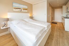 1-Zimmer-Appartement mit feststehendem Doppelbett und Kleiderschrank