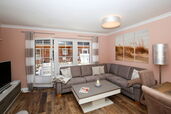 Wohnzimmer mit Ecksofa und Zugang zur Terrasse