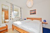 Schlafzimmer mit großem Spiegel und Doppelbett 