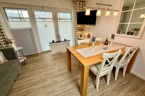 Wohnzimmer mit Sofa, Sessel, TV und Austritt auf die Südterrasse