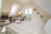 Wohn-/Schlafbereich mit feststehendem Doppelbett und Essplatz