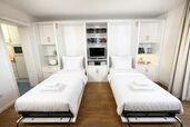 Wohnzimmer mit zwei ausgeklappten Einzelschrankbetten